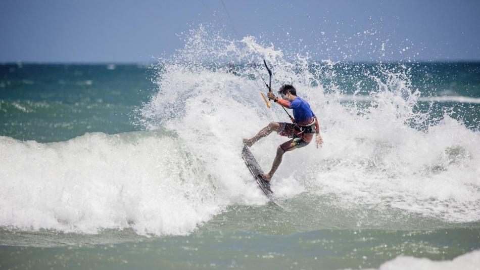 kitesurfer hitting the lip and throwing some spray on a wave in Taiba Brazil